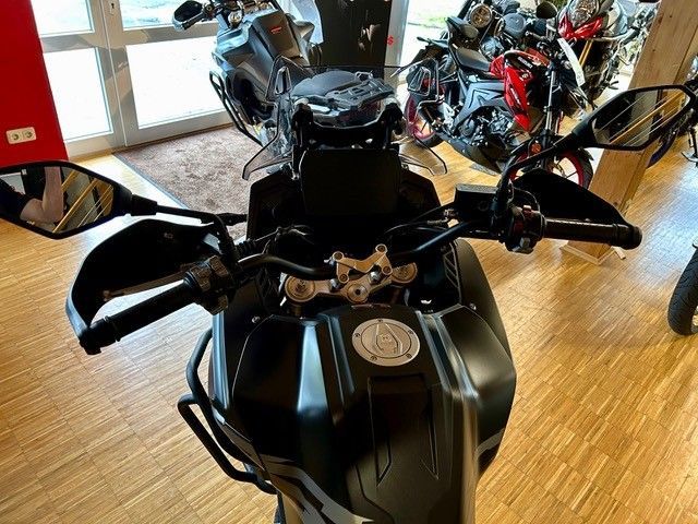 In einem Ausstellungsraum steht ein schwarzes Motorrad.