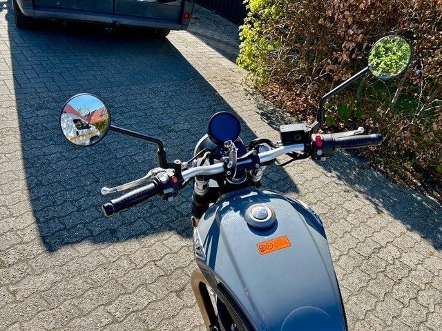 Ein Motorrad ist am Straßenrand neben einem Auto geparkt.