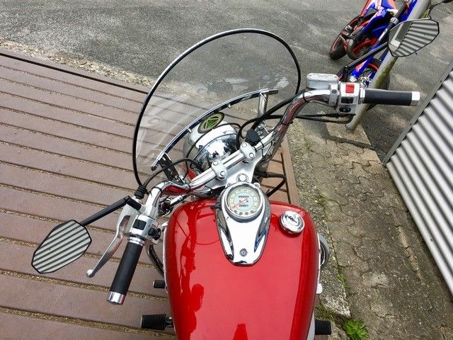 Ein rotes Motorrad ist auf einem Holzdeck geparkt