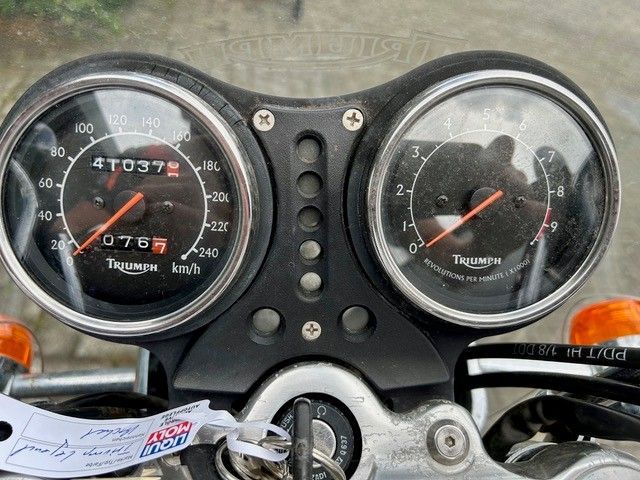 Motorrad-Armaturenbrett mit zwei runden Anzeigen für Geschwindigkeit und Drehzahl, Schlüssel im Zündschloss.