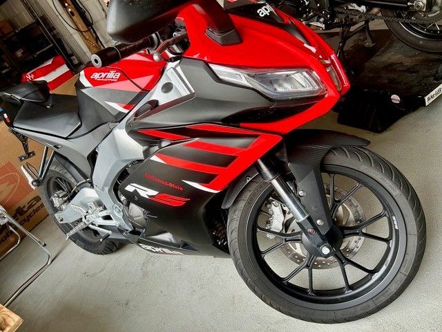 Rotes und silbernes Sportmotorrad in einer Garage geparkt, Seitenansicht