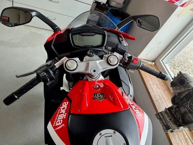 Rotes Sportmotorrad von oben gesehen, in einer Halle geparkt, Spiegel und Lenker sind sichtbar.