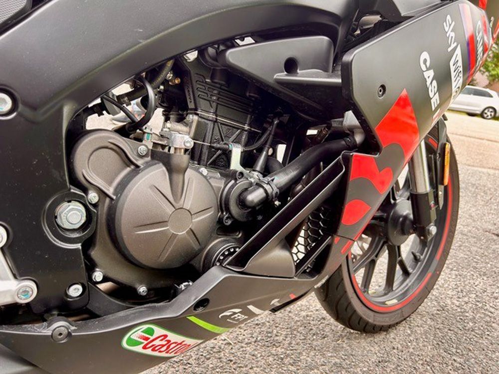 Nahaufnahme eines schwarzen Sportmotorrads mit roten Akzenten und sichtbaren Motor- und Verkleidungsdetails