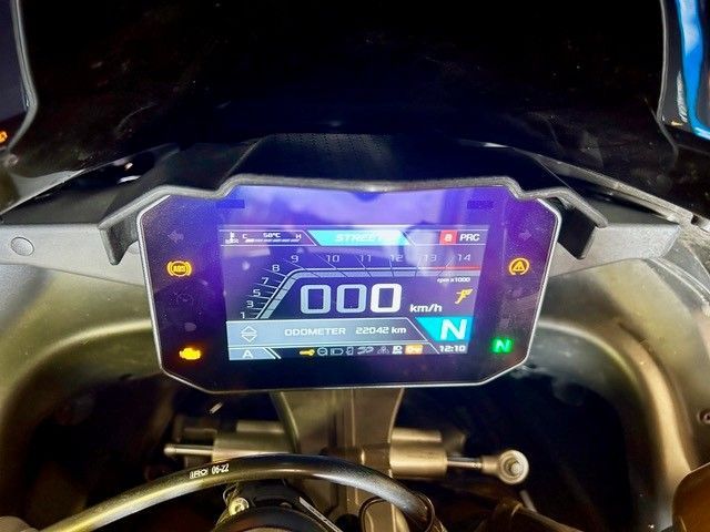 Das digitale Armaturenbrett des Motorrads leuchtet blau und violett und zeigt 000 sowie die Leerlaufanzeige an.