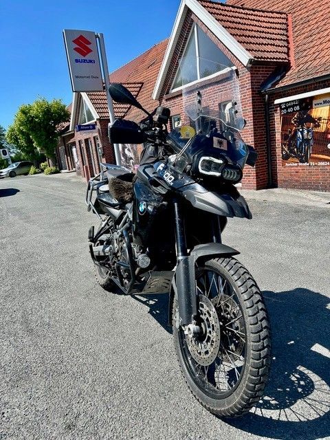 Ein Motorrad ist vor einem Suzuki-Laden geparkt