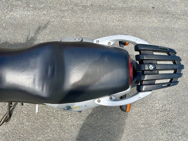 Draufsicht auf einen schwarzen Motorradsitz und Gepäckträger auf dem Asphalt