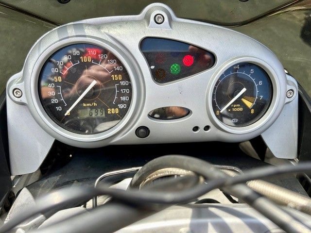 Motorrad-Armaturenbrett mit zwei analogen Anzeigen, Kontrollleuchten und sichtbarem Lenker