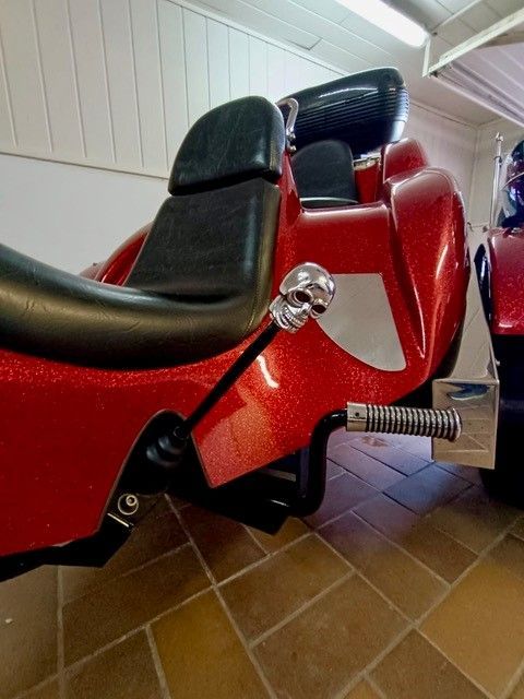 Ein rotes Motorrad ist auf einem gefliesten Boden geparkt