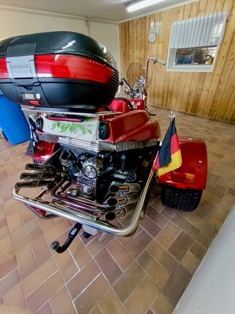 Ein rotes Motorrad mit einer deutschen Flagge auf dem Heck steht in einer Garage.