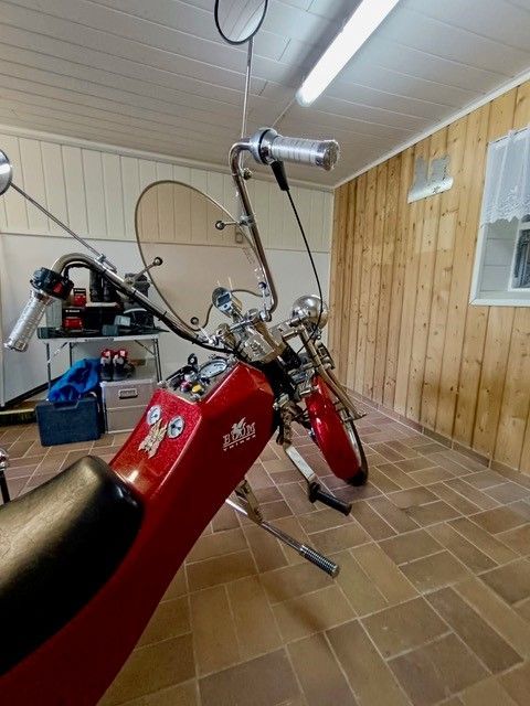 Ein rotes Motorrad mit Windschutzscheibe steht in einer Garage