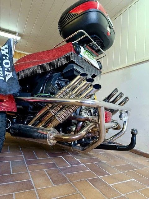 Ein Motorrad ist in einer Garage geparkt, auf der eine Flagge mit der Aufschrift „Woa“ steht