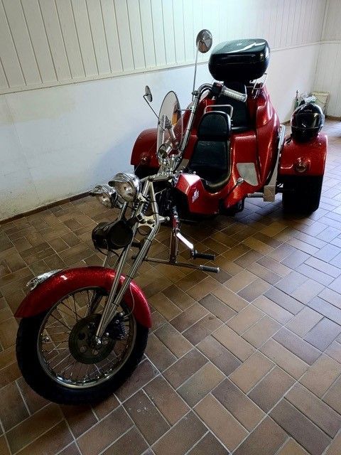 Ein rotes Motorrad ist auf einem gefliesten Boden geparkt