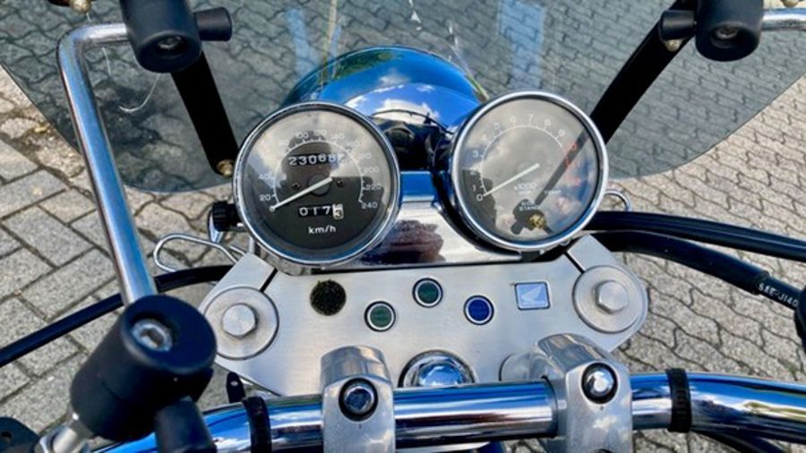 Motorrad-Armaturenbrett mit Anzeigen und Lenker, das Geschwindigkeit und Motorstatus anzeigt.