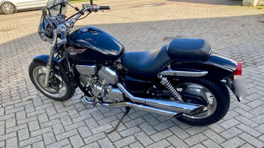 Schwarzes Honda-Motorrad auf Pflastersteinen geparkt.