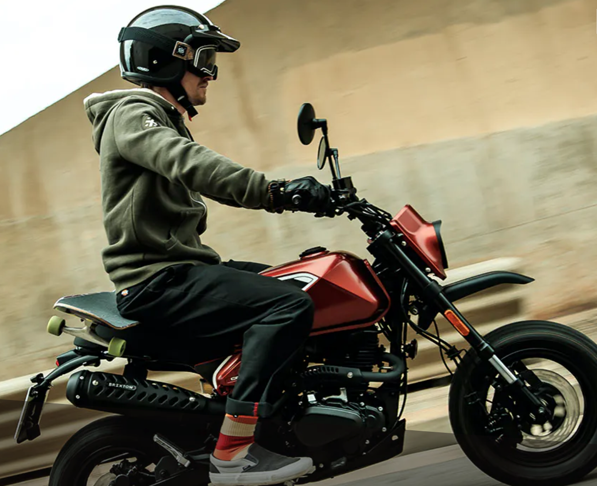 Ein Mann mit Helm und Schutzbrille fährt ein rotes Motorrad