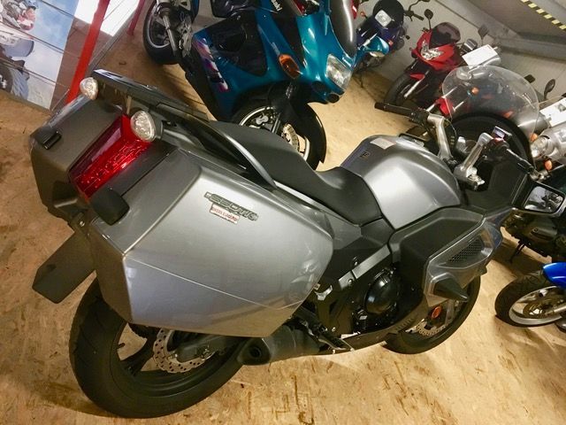 Ein Motorrad ist in einer Garage mit anderen Motorrädern geparkt