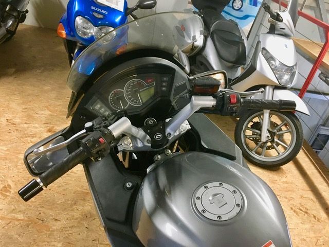 Ein Motorrad ist in einer Garage mit anderen Motorrädern geparkt