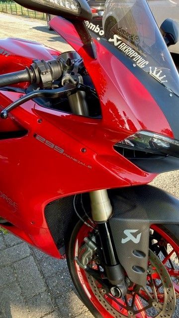 Ein rotes Motorrad steht am Straßenrand