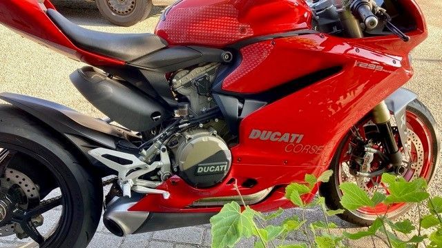 Ein rotes Ducati-Motorrad ist am Straßenrand geparkt.
