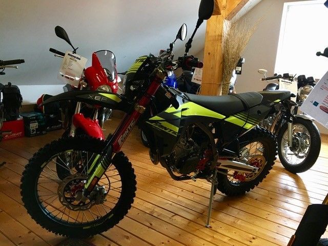 Ein Motorrad ist in einem Raum mit anderen Motorrädern geparkt