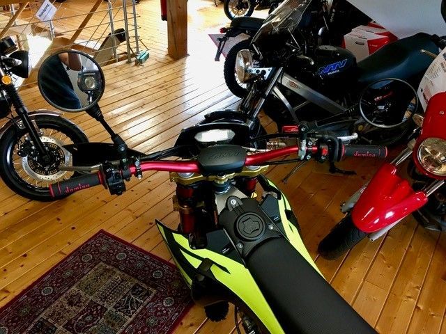 Ein Motorrad ist in einem Raum mit anderen Motorrädern geparkt.