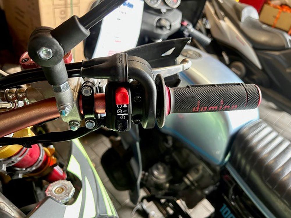 Motorradlenker mit schwarzem und rotem Gasgriff und Spiegel (Nahaufnahme)