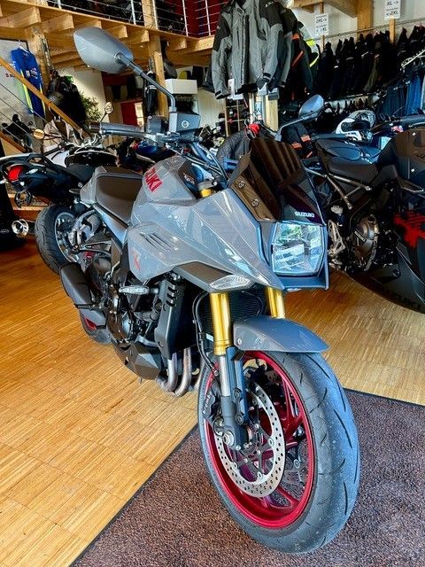 Silbernes Sportmotorrad mit roten Felgen, ausgestellt in einem Ausstellungsraum