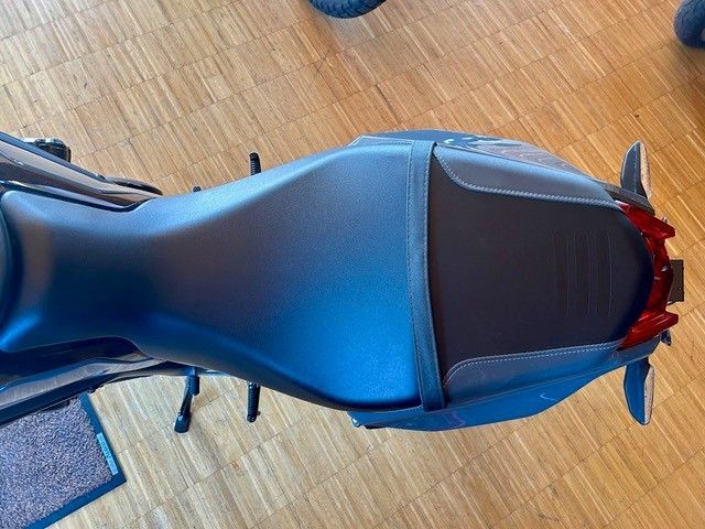 Blauer Motorradsitz, von oben auf einem Holzboden gesehen.