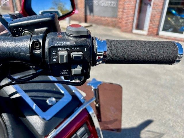 Motorradlenker-Bedienelemente mit schwarzem Griff und rotem Schalter in Nahaufnahme im Freien