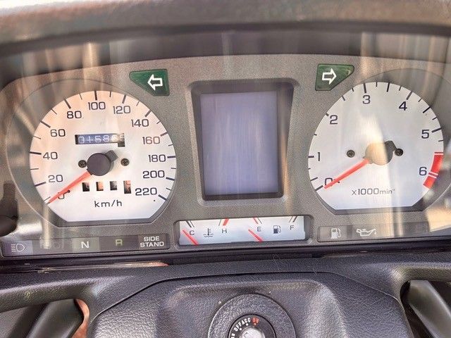 Armaturenbrett eines Autos mit eingeschaltetem Tachometer, Drehzahlmesser und Warnleuchten.