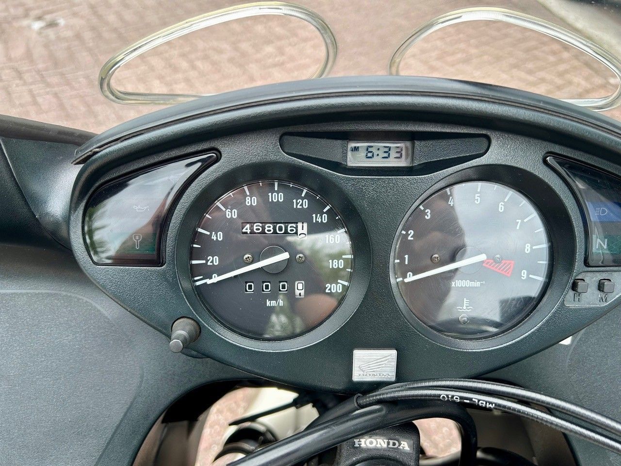 Armaturenbrett des Rollers mit Tachometer, Tankanzeige und kleinem Kilometerzähler unter einer durchsichtigen Kunststoffabdeckung
