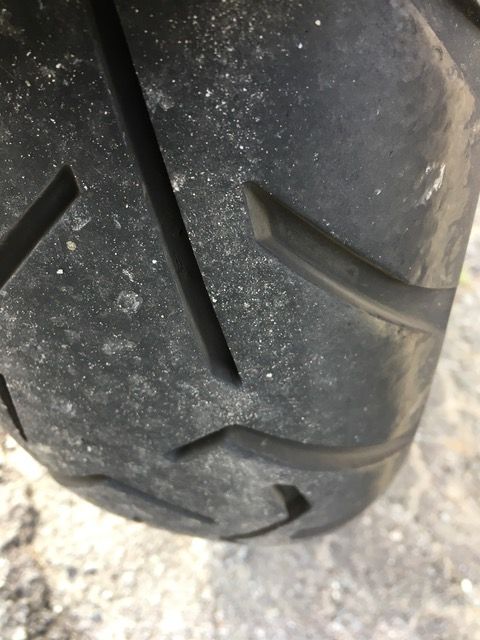 Eine Nahaufnahme eines Motorradreifens auf einer Betonoberfläche.