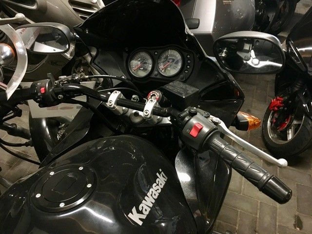 Ein schwarzes Kawasaki-Motorrad steht in einer Garage