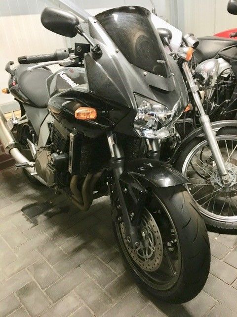 Ein schwarzes Motorrad ist neben einem anderen Motorrad geparkt