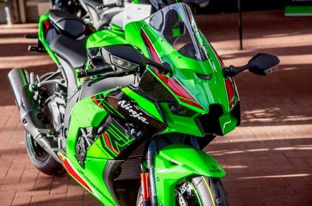 Ein grünes Ninja-Motorrad ist auf einem Ziegelboden geparkt.