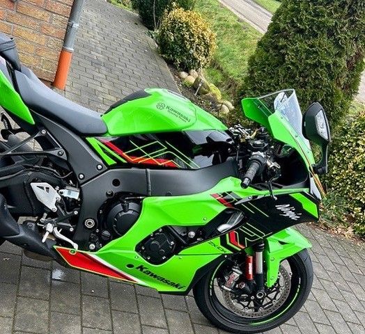 Ein grünes Kawasaki-Motorrad ist auf einem Bürgersteig geparkt