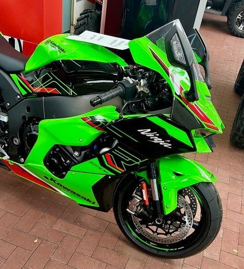 Ein grünes Ninja-Motorrad ist auf einem Ziegelboden geparkt