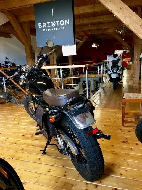 Ein Motorrad in einem Raum mit einem Schild mit der Aufschrift „Brixton“