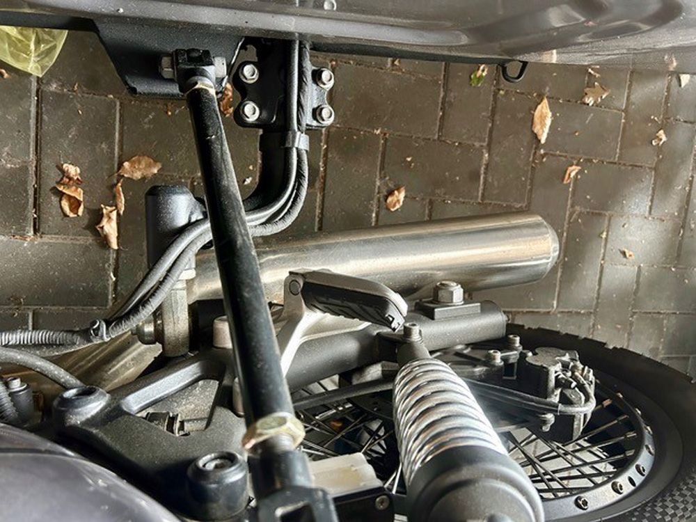 Unterboden eines Motorrads mit Auspuffrohr, Federung und Hinterrad