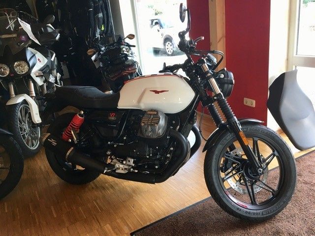 Ein weiß-schwarzes Motorrad steht in einem Ausstellungsraum