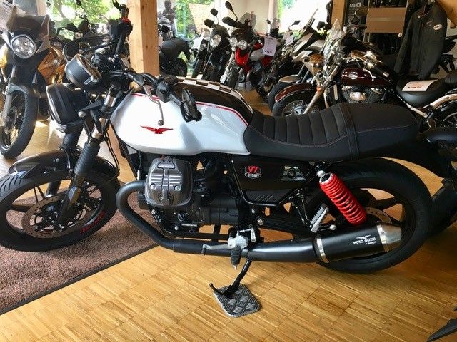 Ein schwarz-weißes Motorrad steht in einem Ausstellungsraum