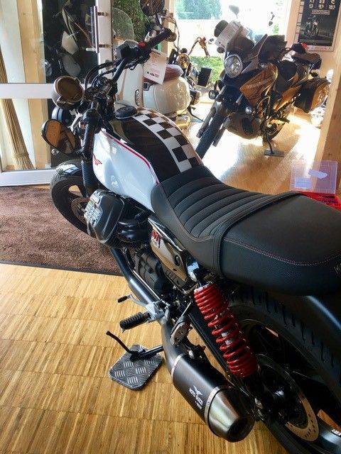 Ein Motorrad ist in einem Raum mit anderen Motorrädern geparkt