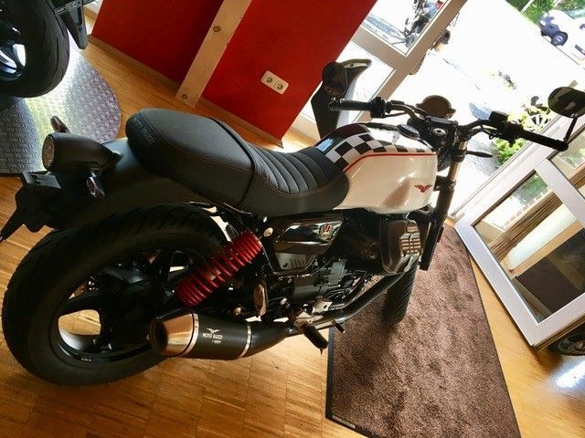 Ein schwarz-weißes Motorrad ist in einem Raum geparkt