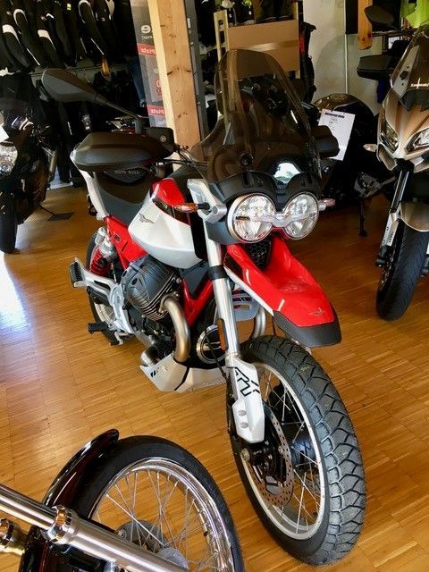 Ein rot-weißes Motorrad ist in einem Raum geparkt