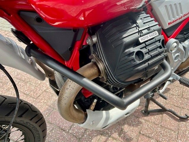 Nahaufnahme eines roten Motorradmotors und Auspuffrohrs auf einem Ständer