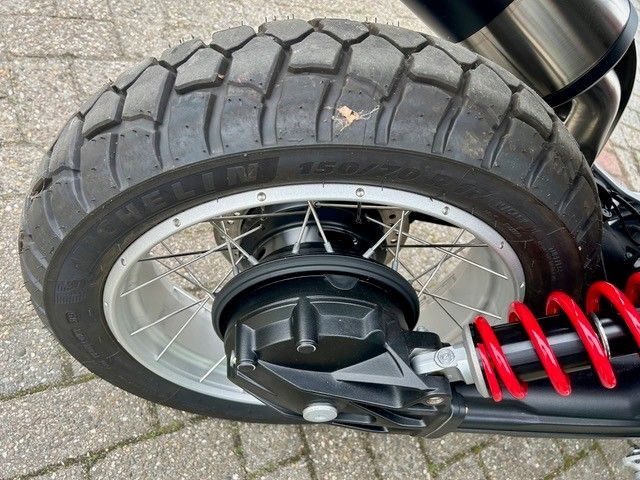 Nahaufnahme eines Motorradhinterrades mit roter Federung und schwarzem Nabenmotor.