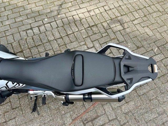 Schwarzer Motorradsitz und Heckrahmen, von oben auf einer gepflasterten Fläche gesehen.