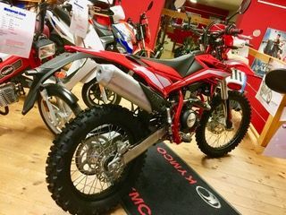 In einem Ausstellungsraum steht eine Reihe von Dirtbikes aufgereiht.