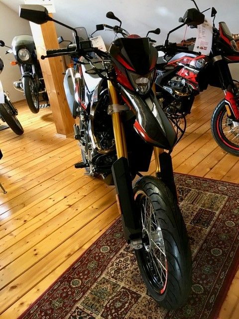 Ein Motorrad ist in einem Raum mit anderen Motorrädern geparkt