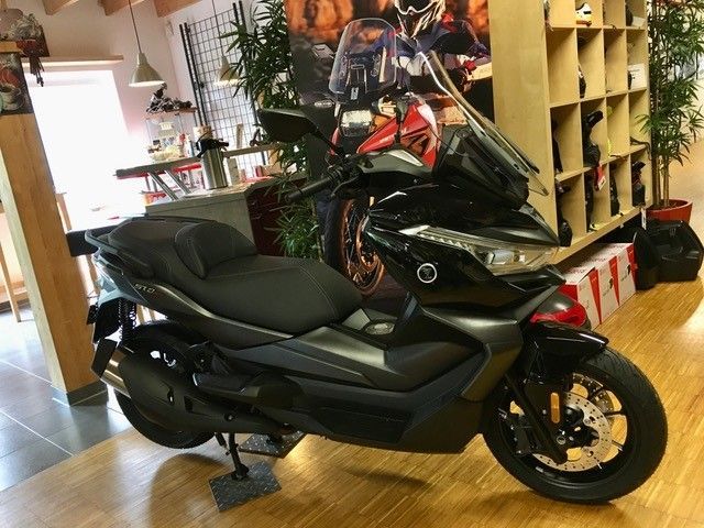 Ein schwarzer Roller steht auf einem Holzboden in einem Raum